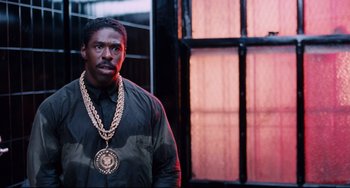 Movie still from “Deep Cover” (1992), directed by Bill Duke – A man wearing a large gold chain around his neck; Close Up shot, Low angle