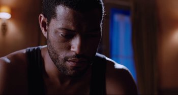 Movie still from “Deep Cover” (1992), directed by Bill Duke – A man's face in a dark room; Close Up shot, High angle