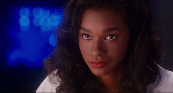 Movie still from “Deep Cover” (1992), directed by Bill Duke – A person with long black hair; Close Up shot, Over the shoulder angle