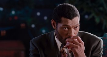 Movie still from “Deep Cover” (1992), directed by Bill Duke – A man in a suit and tie holding his hand to his mouth; Close Up shot, High angle