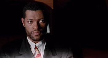 Movie still from “Deep Cover” (1992), directed by Bill Duke – A person wearing a suit and tie; Close Up shot, Low angle