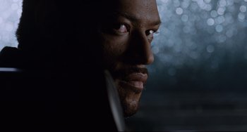 Movie still from “Deep Cover” (1992), directed by Bill Duke – A man's face in a darkened room; Close Up shot, Over the shoulder angle