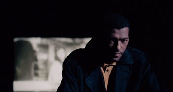 Movie still from “Deep Cover” (1992), directed by Bill Duke – A man in a yellow shirt and a black jacket; Close Up shot, High angle