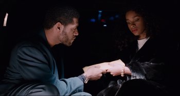 Movie still from “Deep Cover” (1992), directed by Bill Duke – A man and a woman sitting in a car holding papers; Medium shot, Over the shoulder angle