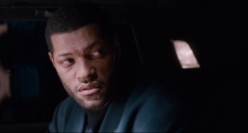 Movie still from “Deep Cover” (1992), directed by Bill Duke – A person in a car looking at the camera; Close Up shot, Over the shoulder angle