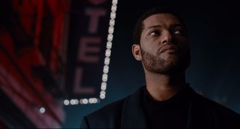 Movie still from “Deep Cover” (1992), directed by Bill Duke – A person wearing a suit; Close Up shot, Low angle