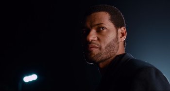 Movie still from “Deep Cover” (1992), directed by Bill Duke – A person wearing a black t - shirt; Close Up shot, Low angle