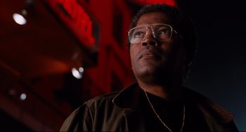Movie still from “Deep Cover” (1992), directed by Bill Duke – A person wearing glasses and looking up; Close Up shot, Low angle