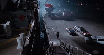 Movie still from “Deep Cover” (1992), directed by Bill Duke – A man walking down a street at night; Extreme Wide shot, High angle