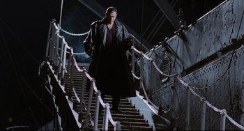 Movie still from “Deep Cover” (1992), directed by Bill Duke – A man walking down a set of stairs at night; Wide shot, Low angle