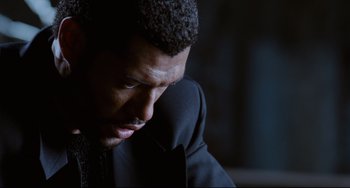 Movie still from “Deep Cover” (1992), directed by Bill Duke – A person wearing a suit; Close Up shot, High angle