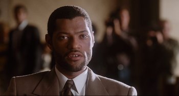 Movie still from “Deep Cover” (1992), directed by Bill Duke – A person wearing a suit and tie; Close Up shot, Low angle