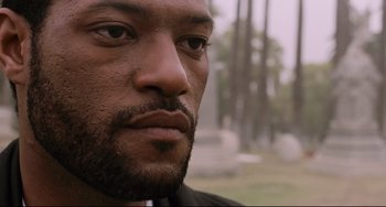 Movie still from “Deep Cover” (1992), directed by Bill Duke – A man's face with trees in the background; Close Up shot, Low angle