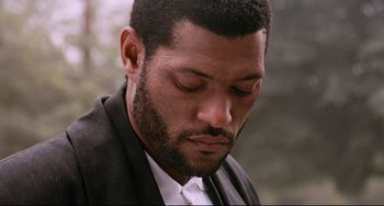 Movie still from “Deep Cover” (1992), directed by Bill Duke – A person wearing a suit and tie; Close Up shot, Low angle