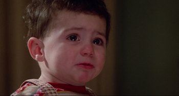 Movie still from “Defending Your Life” (1991), directed by Albert Brooks – A child crying with his eyes closed; Close Up shot, High angle