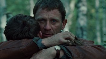 Movie still from “Defiance” (2008), directed by Edward Zwick – A person hugging a person with a watch; Close Up shot, Over the shoulder angle