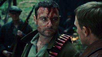 Movie still from “Defiance” (2008), directed by Edward Zwick – A person with blood on his face; Close Up shot, Over the shoulder angle