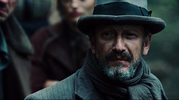 Movie still from “Defiance” (2008), directed by Edward Zwick – A man wearing a hat and a scarf; Close Up shot, Low angle
