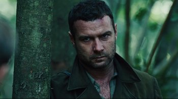 Movie still from “Defiance” (2008), directed by Edward Zwick – A person wearing a jacket near a tree; Close Up shot, Over the shoulder angle