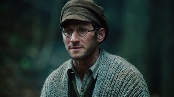 Movie still from “Defiance” (2008), directed by Edward Zwick – A person wearing glasses and a hat; Close Up shot, Low angle
