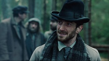 Movie still from “Defiance” (2008), directed by Edward Zwick – A man with a beard wearing a black hat; Close Up shot, Low angle