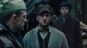 Movie still from “Defiance” (2008), directed by Edward Zwick – A group of men standing next to each other; Close Up shot, Over the shoulder angle