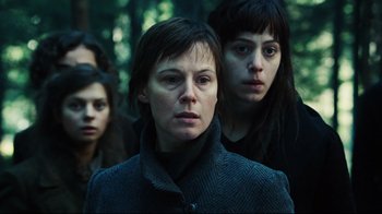 Movie still from “Defiance” (2008), directed by Edward Zwick – A group of people standing next to each other in the woods; Close Up shot, Low angle