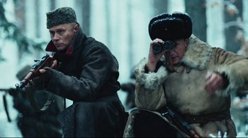 Movie still from “Defiance” (2008), directed by Edward Zwick – A man and a woman looking through binoculars; Medium shot, Low angle