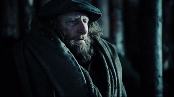 Movie still from “Defiance” (2008), directed by Edward Zwick – A man with a long beard wearing a hat and a scarf; Close Up shot, Low angle