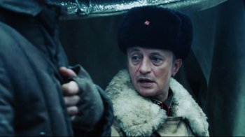 Movie still from “Defiance” (2008), directed by Edward Zwick – An older woman wearing a fur coat and a hat; Close Up shot, Over the shoulder angle