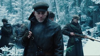 Movie still from “Defiance” (2008), directed by Edward Zwick – A group of men standing next to each other in the snow; Medium shot, Low angle