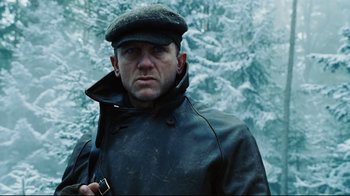 Movie still from “Defiance” (2008), directed by Edward Zwick – A man wearing a hat and a leather jacket; Close Up shot, Low angle