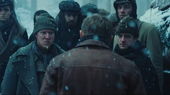 Movie still from “Defiance” (2008), directed by Edward Zwick – A group of men standing in the snow; Medium shot, Over the shoulder angle
