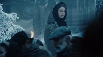 Movie still from “Defiance” (2008), directed by Edward Zwick – A woman in a hooded jacket standing next to a crowd of people; Medium shot, Over the shoulder angle