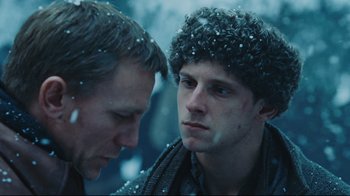 Movie still from “Defiance” (2008), directed by Edward Zwick – Two men looking at one another in the snow; Close Up shot, Over the shoulder angle