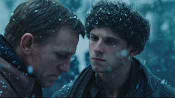 Movie still from “Defiance” (2008), directed by Edward Zwick – Two men standing next to each other in the snow; Close Up shot, Over the shoulder angle