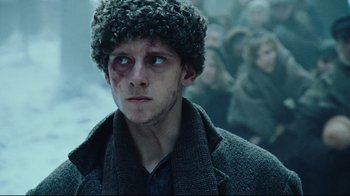 Movie still from “Defiance” (2008), directed by Edward Zwick – A person wearing a coat and a hat; Close Up shot, Low angle