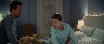 Movie still from “Definitely, Maybe” (2008), directed by Adam Brooks – A young girl sitting on a bed with a teddy bear; Medium shot, High angle