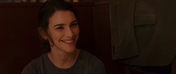 Movie still from “Definitely, Maybe” (2008), directed by Adam Brooks – A person sitting in a chair smiling; Close Up shot, Over the shoulder angle