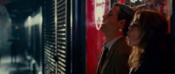 Movie still from “Definitely, Maybe” (2008), directed by Adam Brooks – A man standing in front of a building smoking a cigarette; Medium shot, Over the shoulder angle