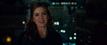 Movie still from “Definitely, Maybe” (2008), directed by Adam Brooks – A woman smiling for the camera in front of a city skyline at night; Close Up shot, Over the shoulder angle