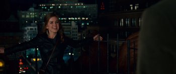 Movie still from “Definitely, Maybe” (2008), directed by Adam Brooks – A woman standing in front of a fence at night; Medium shot, Over the shoulder angle
