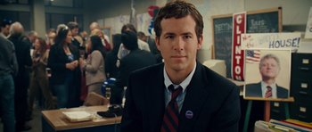 Movie still from “Definitely, Maybe” (2008), directed by Adam Brooks – A man in a suit and tie at an event; Close Up shot, Over the shoulder angle