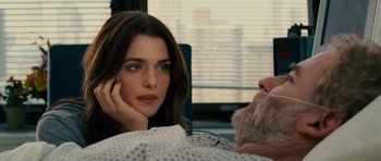 Movie still from “Definitely, Maybe” (2008), directed by Adam Brooks – A woman sitting next to a man in a hospital bed; Close Up shot, Over the shoulder angle
