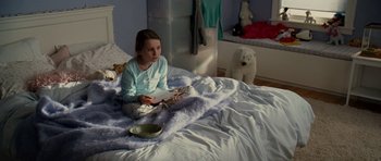 Movie still from “Definitely, Maybe” (2008), directed by Adam Brooks – A young girl sitting on a bed with a book in her hands; Medium shot, High angle