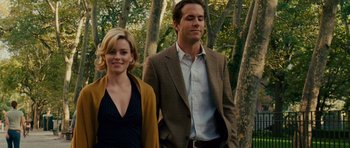 Movie still from “Definitely, Maybe” (2008), directed by Adam Brooks – A man and a woman standing next to each other in front of trees; Medium shot, Over the shoulder angle