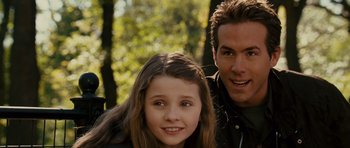 Movie still from “Definitely, Maybe” (2008), directed by Adam Brooks – A man and a girl smiling for the camera; Close Up shot, Over the shoulder angle