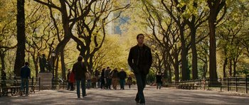 Movie still from “Definitely, Maybe” (2008), directed by Adam Brooks – A man walking down a sidewalk near a crowd of onlookers; Wide shot, Over the shoulder angle