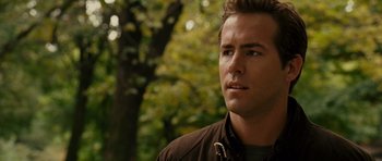 Movie still from “Definitely, Maybe” (2008), directed by Adam Brooks – A person wearing a jacket near a tree; Close Up shot, Over the shoulder angle