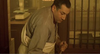 Movie still from “Delicatessen” (1991), directed by Marc Caro – A man wearing an apron holding a wooden spoon; Medium shot, Low angle